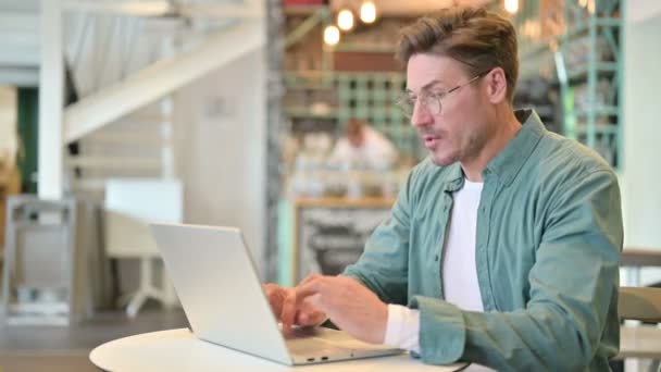 Enfermo hombre de mediana edad con la tos del ordenador portátil en Café — Vídeos de Stock