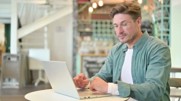 Polegares para cima pelo homem de meia-idade positivo que trabalha no café — Vídeo de Stock