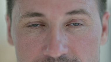 Orta yaşlı adamın yanıp sönen gözlerine yaklaş. 