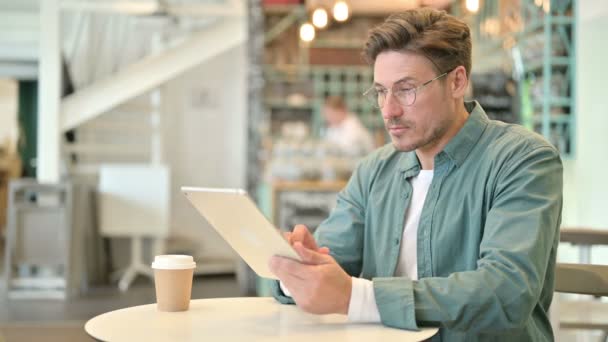 Ernsthafter Profi mittleren Alters mit Tablet im Cafe — Stockvideo