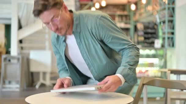 Hombre de mediana edad que viene, la apertura de la computadora portátil para el trabajo en Café — Vídeo de stock