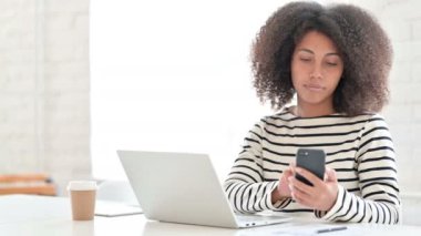 Genç Afrikalı Kadın Tasarımcı Laptop ve Smartphone üzerinde çalışıyor