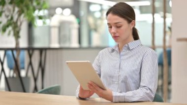 Ofiste Dijital Tablet üzerinde çalışan Çekici Genç Kadın 