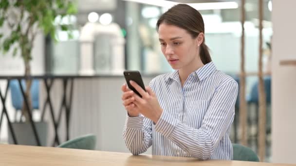 Jovem mulher séria usando Smartphone no escritório — Vídeo de Stock