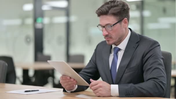 Sérieux professionnel moyen âge homme d'affaires utilisant la tablette dans le bureau — Video