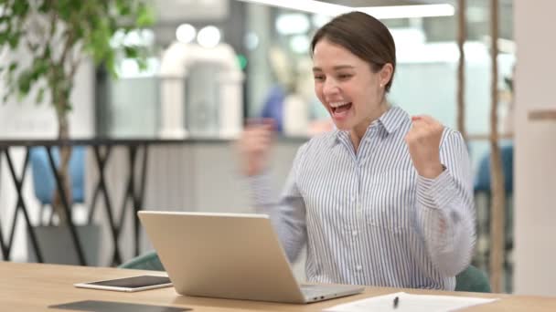Schöne junge Frau feiert Erfolg auf Laptop im Büro — Stockvideo