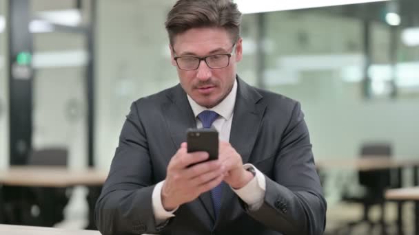 Retrato de hombre de negocios de mediana edad utilizando Smartphone — Vídeo de stock