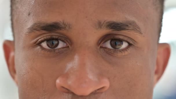 Fechar os olhos cintilantes do homem africano casual — Vídeo de Stock