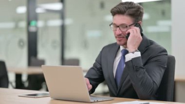 Bilgisayarlı Orta Çağ İşadamı Ofiste Akıllı Telefonla Konuşuyor 
