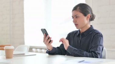 Akıllı telefondan konuşan kızgın genç Hintli kadın. 