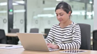 Dizüstü bilgisayarlı hayal kırıklığına uğramış Hintli kadın başparmaklarını indiriyor. 