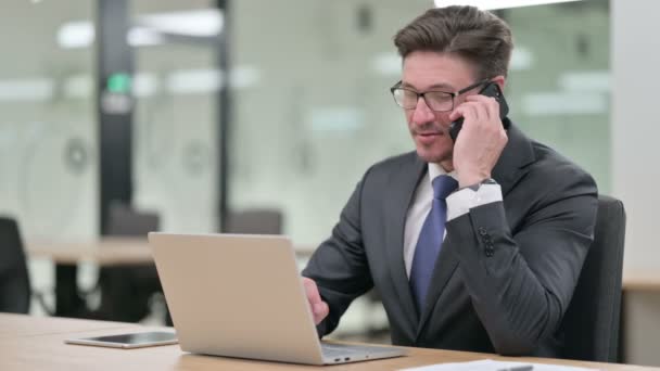 Středověký podnikatel s notebookem na Smartphone v kanceláři — Stock video