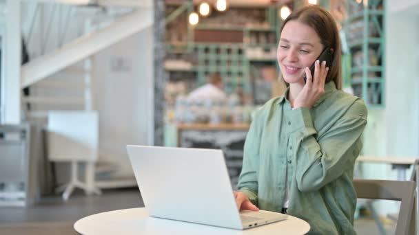 Mulher com Laptop Falando em Smartphone no Café — Vídeo de Stock