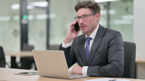 Podnikatel mluví po telefonu v práci — Stock video