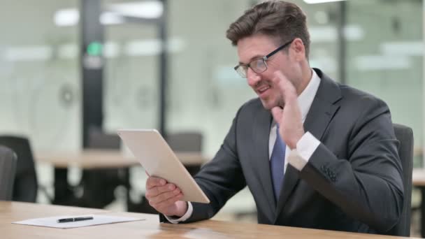 Profesionální středověký podnikatel dělá video chat na tabletu v kanceláři — Stock video