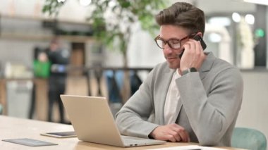 Bilgisayarlı Orta Yaşlı Adam Akıllı Telefonla Konuşuyor 