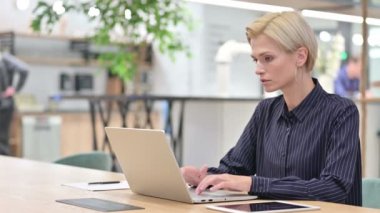 Dizüstü bilgisayarda çalışan stresli kadın ofiste bilek ağrısı çekiyor. 