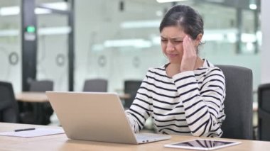 Dizüstü bilgisayarı olan stresli Hintli kadın baş ağrısı çekiyor. 