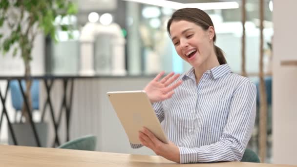 Веселая молодая женщина делает видео-чат на цифровом планшете в офисе — стоковое видео