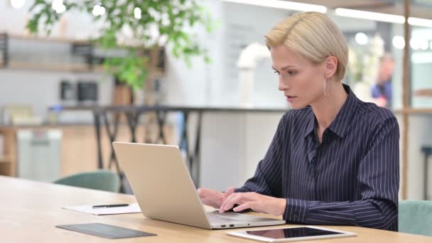 Bella donna d'affari che pensa e lavora sul computer portatile in ufficio — Video Stock