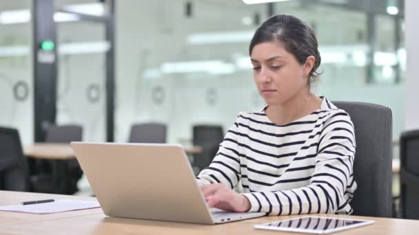 Стрессовая индийская женщина работает на ноутбуке с болями в запястье — стоковое видео