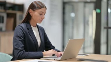 Dizüstü bilgisayarlı Ciddi İş Kadını Kamerayı Gösteriyor 