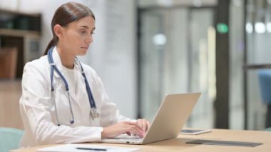 Ofiste dizüstü bilgisayarda çalışan kadın doktor. 