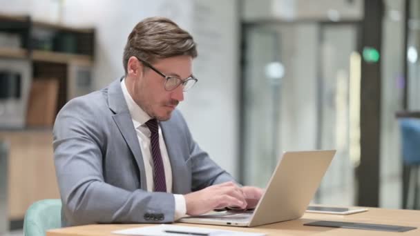 Berufsunternehmer mit Laptop zeigt auf die Kamera — Stockvideo