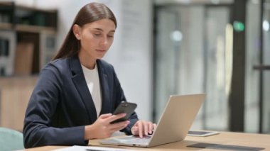 Ofiste Smartphone ve Laptop kullanan hayal kırıklığına uğramış iş kadını 