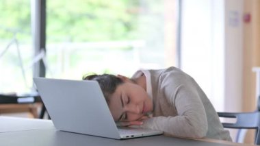 Dizüstü bilgisayarlı yorgun Hintli kadın iş yerinde kestiriyor. 