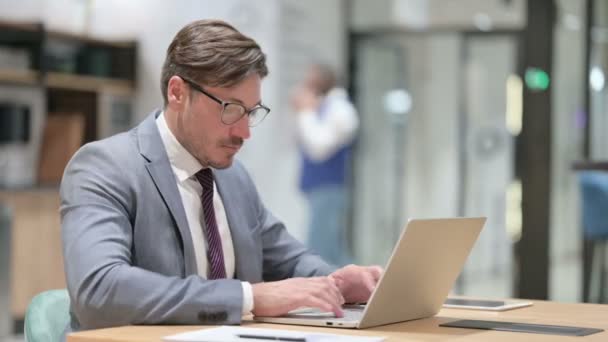 Больной бизнесмен с кашлем на ноутбуке в офисе — стоковое видео