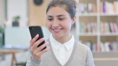 Akıllı telefondan konuşan neşeli Hintli kadın.