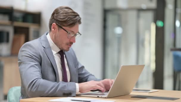 Стресс бизнесмен с ноутбуком с болями в запястье в офисе — стоковое видео