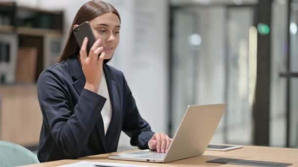 Dizüstü bilgisayarlı iş kadını Ofiste Smartphone 'da konuşuyor — Stok video