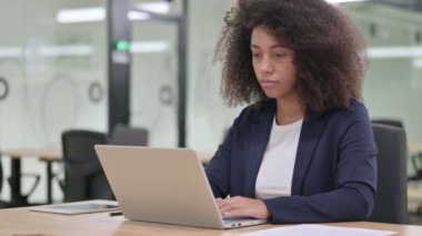 Ciddi bir Afrikalı iş kadını laptopla başını sallıyor, hayır. 