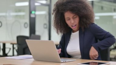 Dizüstü bilgisayarı olan genç Afrikalı İş Kadını Sırt Ağrısı 
