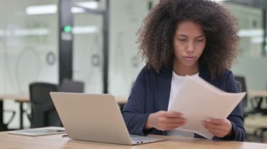 Dizüstü bilgisayarlı Afrikalı İş Kadını Belgelerde Hata Yapıyor 