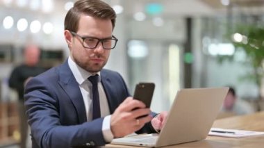 Smartphone ve Laptop kullanan bir iş adamı 