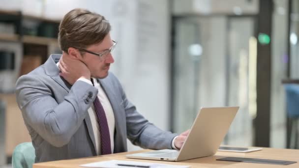 オフィスで首の痛みを持つノートパソコンを持つ疲れたビジネスマン — ストック動画