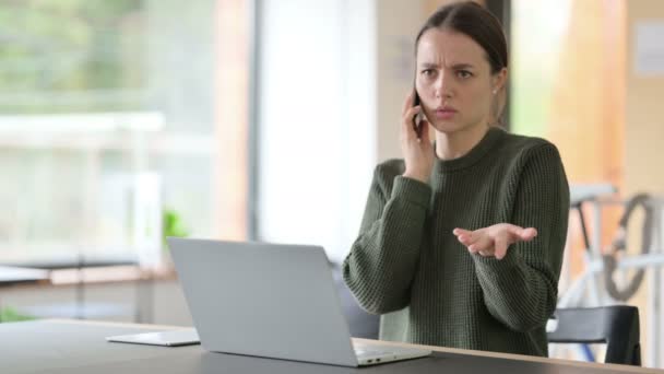 Dühös nő beszél telefonon a munkahelyen — Stock videók