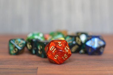 Renkli kırmızı, yeşil ve bue rolü bulanık arkaplanlı masada zar oynuyor