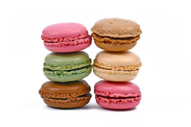 Beyaz arka planda izole edilmiş yeşil, kahverengi, pembe ve sarı Fransız badem kurabiyeleri.