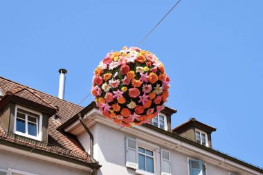 Ettlingen, Almanya - 13 Ağustos 2025: Çiçek küreleri sokağın üzerinde yaz süsü olarak asılı 