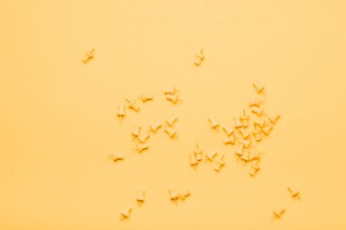 Sarı zemin üzerinde sarı raptiyeler kutuda