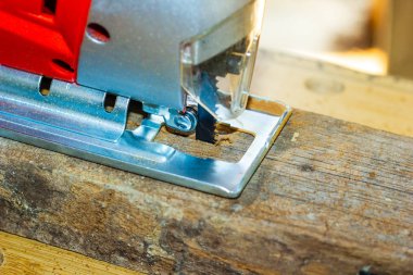 Yakın çekim tahtta elektrikli jigsaw testereleme
