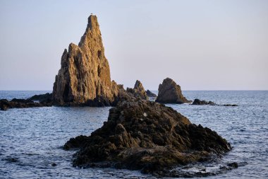 Akdeniz 'de kayalıkların tepesinde bir martı olan kayalar. Arrecife de las Sirenas, Cabo de Gata, İspanya