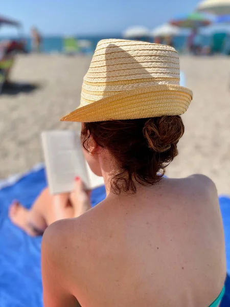 Молодая Женщина Жёлтой Шляпе Читает Книгу Пляже Лицензионные Стоковые Фото