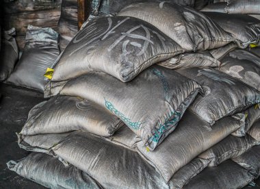 Toprak ve kömür yığını, tarım, ambarda toprak yığını. Markette organik gübre torbaları var. (seçici odaklanma). Çantada mavi metin