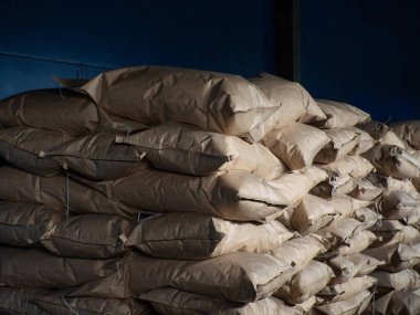 Kömür fabrikasında, koyu kahverengi kese kâğıdı torbaları, mavi sırt.