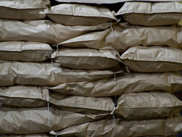 Full brown kraft paper bags with charcoal, at a coals plant, bags texture back